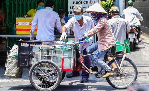  Ngày 3/4, nhiều người có hoàn cảnh khó khăn chờ phát cơm miễn phí tại quận 10, TP.HCM. Mỗi người nghèo, mất thu nhập vì dịch bệnh được nhận một phần đồ ăn và khẩu trang miễn phí, đủ hai bữa sáng - chiều. Nhiều mạnh thường quân cũng ghé địa điểm này quyên góp thêm tiền mặt, gạo, sữa, trái cây, thực phẩm. Ảnh: Xuân Thanh. 