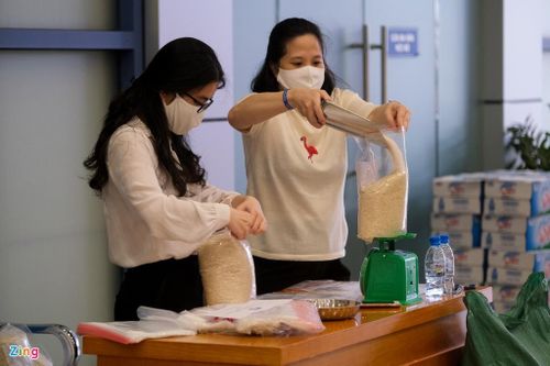  Chị Nguyễn Phương Thanh (Phòng Quản lý Sinh viên, ĐH Kinh tế Quốc dân) có mặt từ sớm để chia gạo thành túi nhỏ. Gạo liên tục được chuyển ra ngoài phục vụ người dân. 
