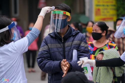  Lực lượng y tế quận Hai Bà Trưng có mặt từ sớm để hỗ trợ đo thân nhiệt và hướng dẫn người dân đeo khẩu trang. Người bị sốt được lấy thông tin gửi về nơi tạm trú để tiếp tục theo dõi. 