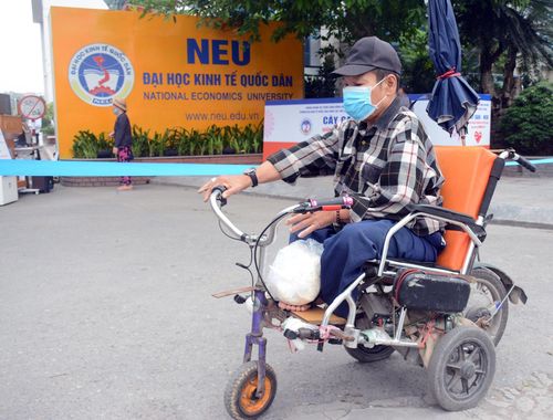 Một người đàn ông khuyết tật vui mừng nhận được số gạo từ chương trình "Cây gạo - NEU giúp người nghèo vượt qua dịch Covid-19" của Trường ĐH Kinh tế Quốc dân.