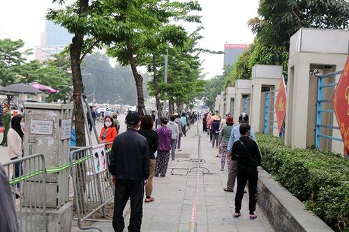 Hàng trăm người dân xếp hàng đúng khoảng cách để vào nhận gạo.