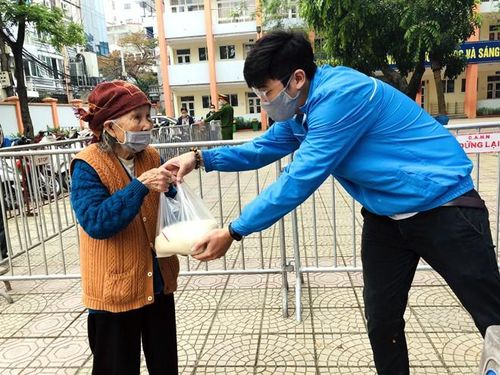 Cụ bà vui mừng khi nhận túi gạo từ tay của những thành viên tham gia phát tặng gạo miễn phí