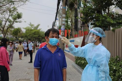 Người dân đến nhận gạo được đo thân nhiệt, xếp hàng đúng cự li. Ảnh: UEF.