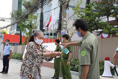 Đeo khẩu trang và rửa tay trước khi vào nhận gạo miễn phí.
