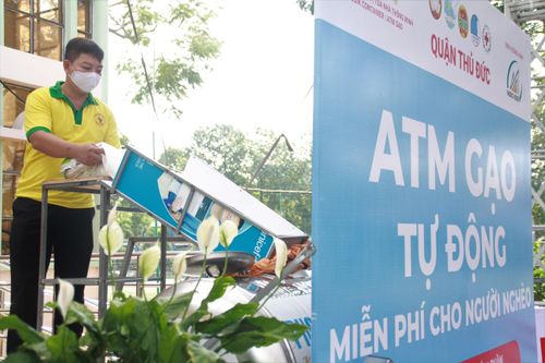 Các tình nguyện viên tiếp gạo vào "máy ATM" khi gạo vơi đi