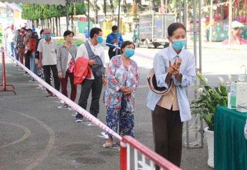 Bà con xếp hàng giãn cách 2 mét trong khi chờ nhận gạo