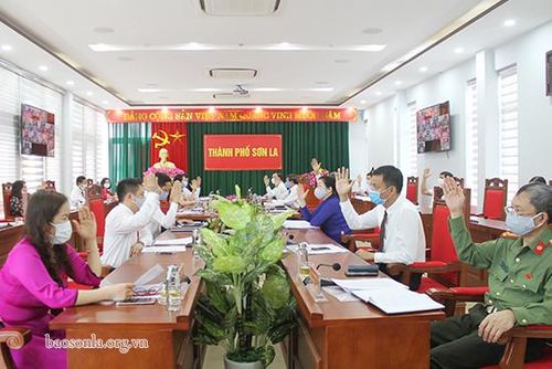 Các đại biểu tại điểm cầu Thành phố biểu quyết thông qua Nghị quyết Kỳ họp. 