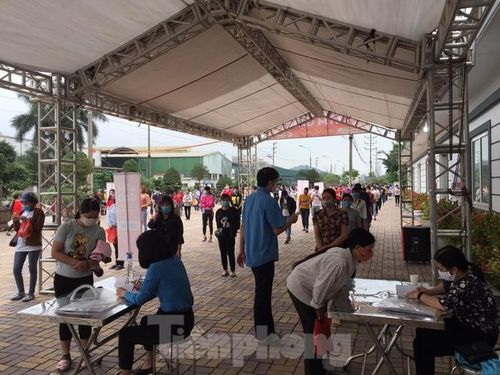 Công nhân được kiểm tra sức khỏe trước khi nhận gạo