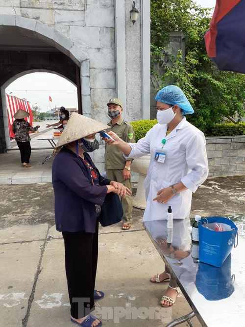 Người dân được đo thân nhiệt khi đến nhận gạo