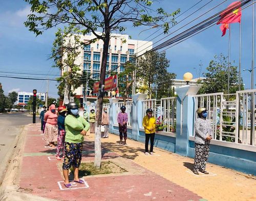 Người dân đến ATM gạo xếp hàng giữ khoảng cách 2m