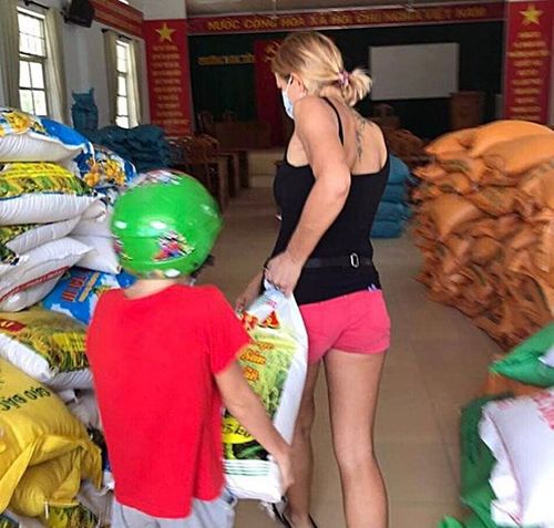 3 mẹ con người Nga mang gạo đến cây "ATM gạo" ủng hộ cho người nghèo. Ảnh: Phương Nam.