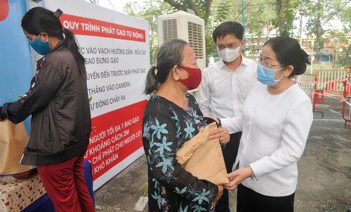 Phó Bí thư Thành ủy TPHCM Võ Thị Dung chia sẻ với bà con khi đến nhận gạo. Ảnh: CAO THĂNG