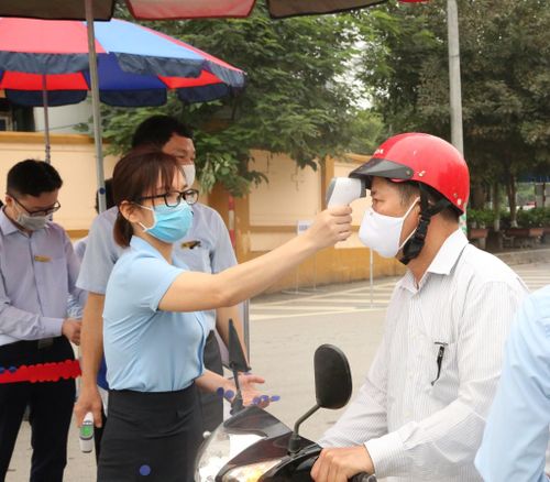 Kiểm tra thân nhiệt cho người dân.