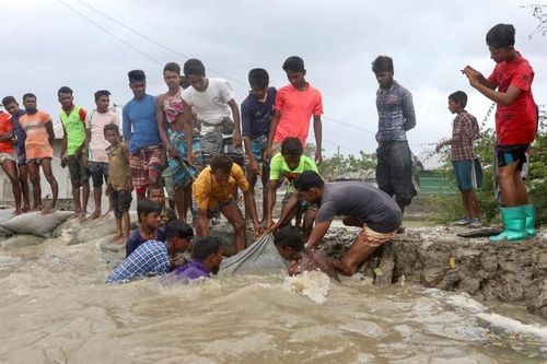  “Chúng tôi đang đối mặt với thứ gây thiệt hại và tàn phá lớn hơn so với Covid-19”, bà Banerjee cho biết. Cho đến nay, virus corona đã khiến 250 tử vong tại bang này. Tại thành phố Kolkata, thủ phủ của bang Tây Bengal, gió mạnh đã làm lật xe hơi, ngã đổ cây cối và cột điện. Một phần của thành phố đã chìm vào bóng tối. Người dân địa phương cố gắng gia cố lại đê bờ trước khi cơn bão Amphan đổ bộ vào vùng ngoại ô Gabura của quận Satkhira, Bangladesh ngày 20/5.