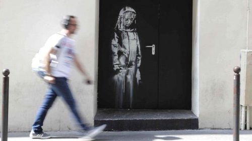 Tác phẩm của Banksy được thực hiện trên cánh cửa thoát hiểm nhà hát Bataclan, Paris. Ảnh: Getty.