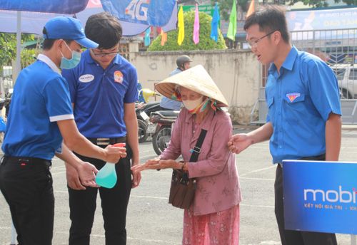 Đoàn viên thanh niên hỗ trợ người dân thực hiện các biện pháp phòng dịch trong lúc đến nhận gạo 