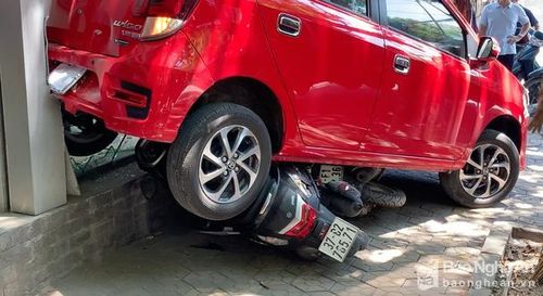 Chiếc xe ô tô đè xe máy và tông sập cửa kính Trung tâm Anh ngữ. Ảnh: Nam Phúc