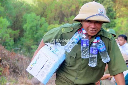 Lực lượng hậu cần băng núi, trèo đèo mang nước uống phục vụ công tác chữa cháy. Đến 18h30 chiều nay, đám cháy vẫn chưa được khống chế mặc dù hàng ngàn người đã nỗ lực tham gia dập lửa. Ảnh: Văn Trường