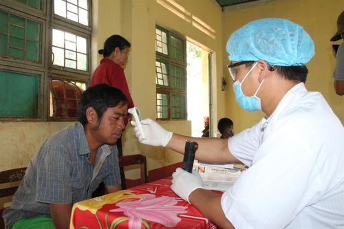  Các y bác sĩ kiểm tra, đo nhiệt độ cho người dân trong làng.