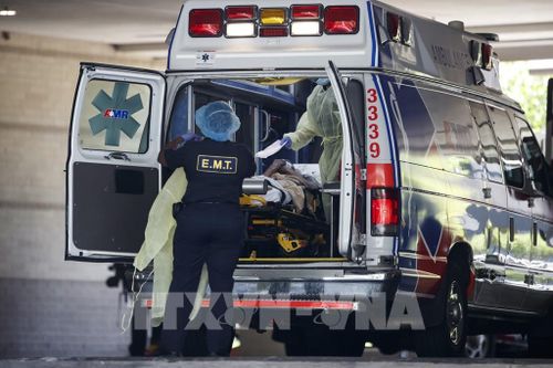 Nhân viên y tế chuyển bệnh nhân COVID-19 tới bệnh viện tại Washington D.C., Mỹ, ngày 13/5/2020. Ảnh: THX/ TTXVN