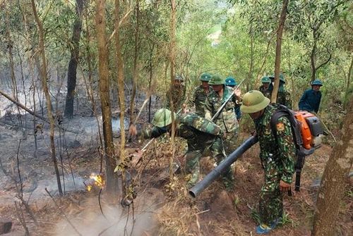 Cán bộ, chiến sĩ Đồn Biên phòng Diễn Thành nỗ lực dập lửa. Ảnh: Lê Thạch