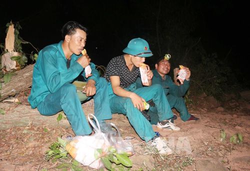 Lực lượng chữa cháy rừng ăn tối ngay tại chỗ để tiếp tục dập lửa rừng. Ảnh: Nguyễn Oanh-TTXVN