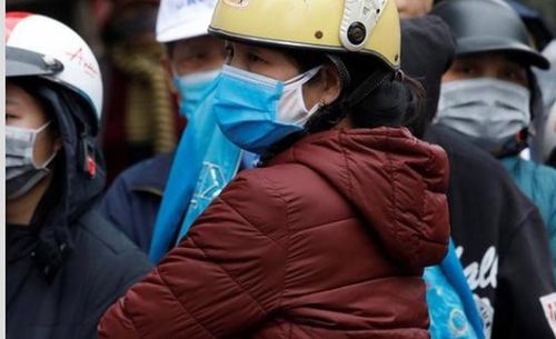 Người dân Việt Nam đeo khẩu trang phòng, chống COVID-19. Ảnh: Khâm/Reuters.
