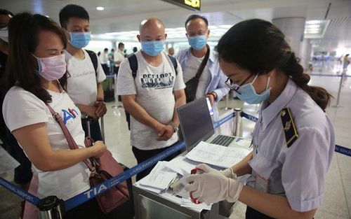 Hành khách khai báo y tế trước khi nhập cảnh vào Việt Nam qua sân bay Tân Sơn Nhất - Ảnh: Hoàng Triều