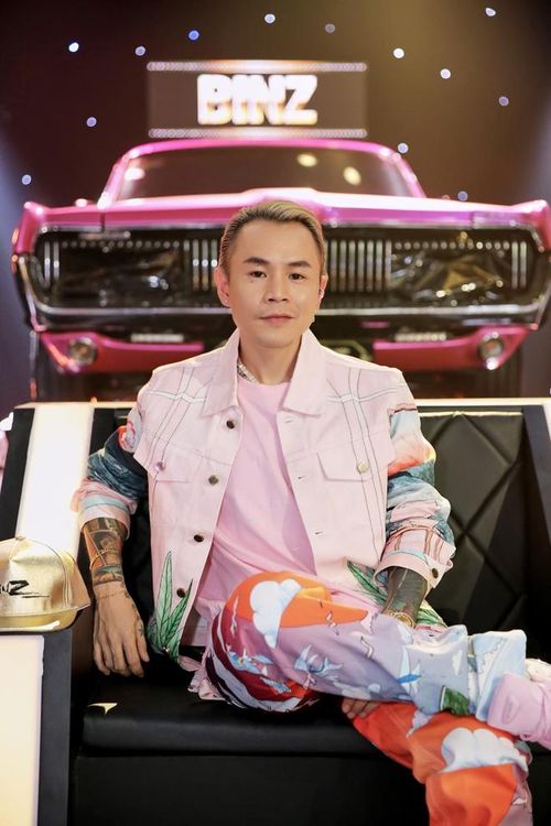  Khác biệt với Suboi, rapper Binz chuộng trang phục có màu sắc sặc sỡ. Anh hướng hình ảnh đến gu ăn mặc đậm chất street wear cùng gam hồng chủ đạo và họa tiết in như bức tranh vẽ màu nước. Điểm nhấn cho bộ cánh chính là phụ kiện xích cổ đính đá và đồng hồ vàng lấp lánh đúng chuẩn dân rapper. Ảnh: Rap Việt. 