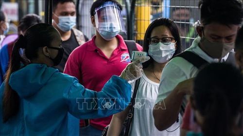 Kiểm tra thân nhiệt phòng lây nhiễm COVID-19 tại một nhà ga ở Manila, Philippines. Ảnh: AFP/TTXVN