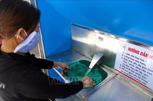 Người dân được nhận gạo tại máy ATM theo quy trình và đúng thời gian lịch hẹn, bảo đảm giãn cách và không phải chờ đợi lâu - Ảnh: TTXVN