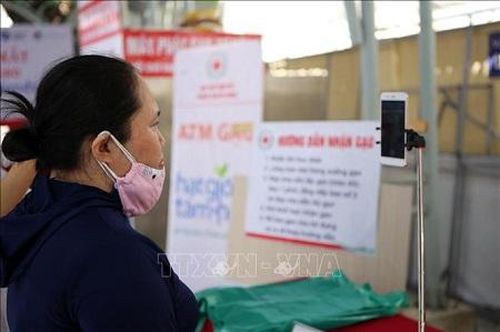 Người dân xác nhận khuôn mặt qua điện thoại để bảo đảm đúng thời gian và đối tượng nhận. Ảnh: TTXVN