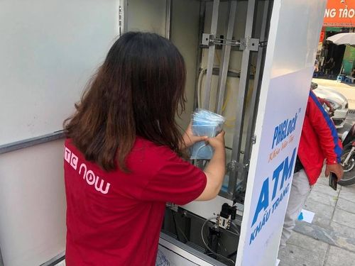 Một nhân viên đưa khẩu trang vào máy.