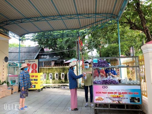 Người dân sát khuẩn tay, giữ khoảng cách khi đến nhận bánh mì