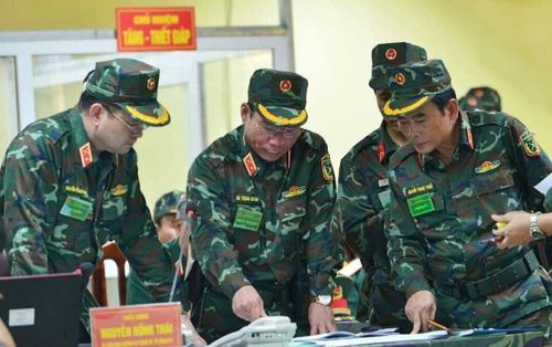 Ngoài ra, quân phục K-19 còn áp dụng một số điểm nổi bật như cúc giữ ống tay áo khi săn lên, bảng tên sử dụng màu ngụy trang đồng bộ với áo, cả chiến sĩ và sĩ quan đều sử dụng áo ngụy trang có 4 túi hộp: 2 trên 2 dưới, trong khi ở các mẫu trước dùng áo 2 túi cho chiến sĩ và 4 túi chỉ cho sĩ quan. Ngoài ra việc áp dụng công nghệ nhuộm vải kiểu mới cũng giúp áo có độ bền màu cực tốt, vượt trội các mẫu cũ. Ảnh: Cán bộ chỉ huy cấp cao chỉ đạo diễn tập với quân phục K-19 mới dành cho cấp tướng và tá.