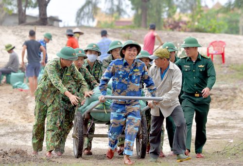 Quân và dân cùng chuyển các bao tải cát ra bờ kè.