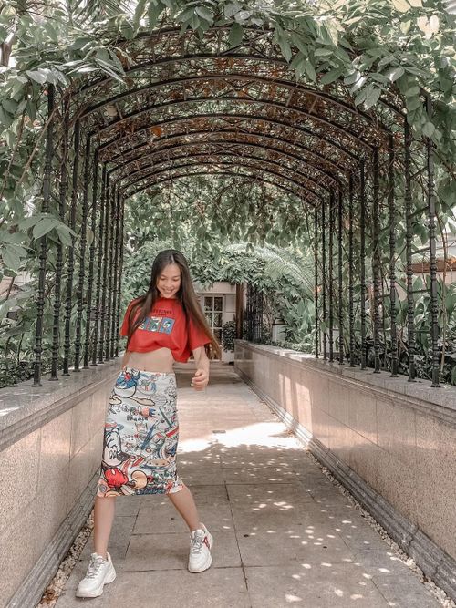 Hiền Thục khéo léo khoe eo thon với áo croptop dáng rộng và chân váy bút chì họa tiết vui mắt.