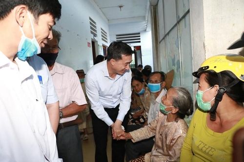 Thứ trưởng Bộ Y tế cùng đoàn công tác thăm, động viên người dân vùng lũ khi đến khám sức khỏe.