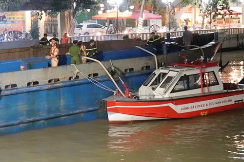Lực lượng chức năng bơm nước vào chiếc sà lan. Ảnh: N.A.