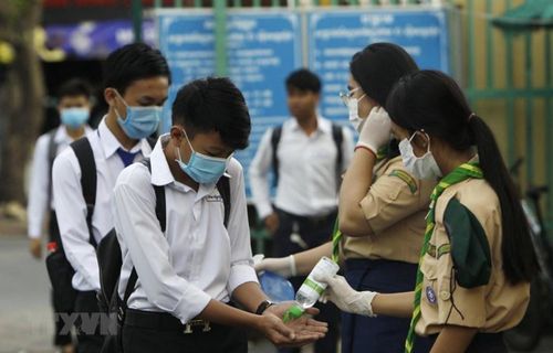 Các học sinh tiến hành sát khuẩn tay nhằm ngăn dịch COVID-19 lây lan, trước khi vào lớp ở Phnom Penh, Campuchia, ngày 2/11/2020. (Ảnh: AFP/TTXVN)