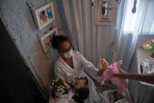 Silva sửa chữa những con búp bê bị hư. Ảnh: AFP