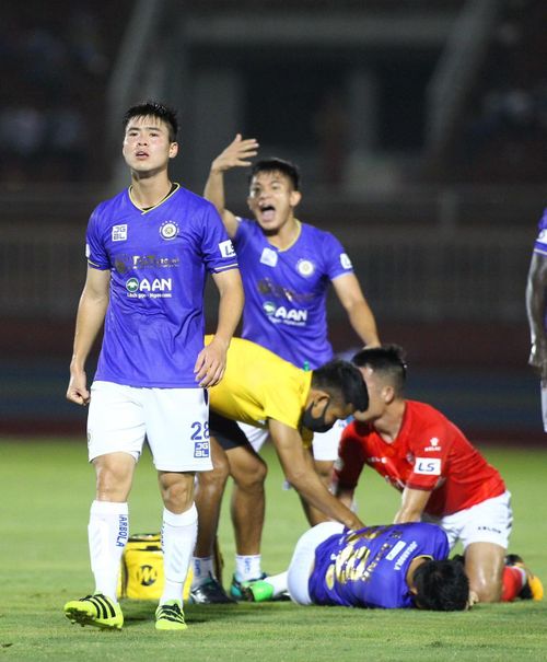  Đỗ Duy Mạnh (trái) và cầu thủ Hà Nội vội vàng gọi cứu thương vào sân. Một năm trước, cũng tại sân Thống Nhất, Duy Mạnh dính một chấn thương nặng khiến anh nghỉ thi đấu gần nửa năm. 
