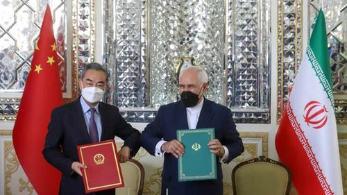Ngoại trưởng Trung Quốc Vương Nghị và người đồng cấp Iran Mohammad Javad Zarif ký thỏa thuận hợp tác hôm 27-3 tại Tehran. Ảnh: CNBC