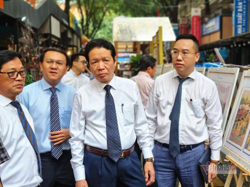 Ông Hoàng Vĩnh Bảo và ông Nguyễn Nguyên xem triển lãm tranh lịch sử Việt Nam tại Đường sách TP.HCM.