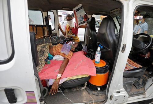 Bệnh nhân COVID-19 thở oxy trong xe hơi chờ được nhập viện. Ảnh: Reuters