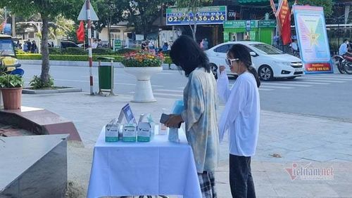 Các bạn trẻ đang sát khuẩn, lấy khẩu trang đeo