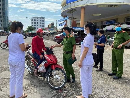 Lực lượng chức năng mời người dân không đeo khẩu trang ở khu vực chợ Vinh vào làm việc
