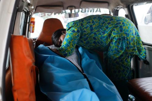  Người phụ nữ khóc bên xác chồng mình, bệnh nhân Covid-19 vừa qua đời, trên xe cứu thương đến lò hỏa táng tại New Delhi. Ảnh: Reuters. 