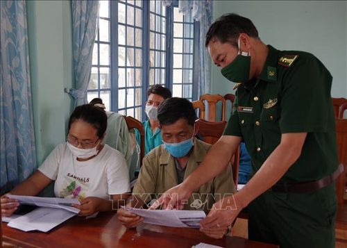 Cán bộ Đồn Biên phòng Sa Loong tại xã Sa Loong, huyện Ngọc Hồi (Kon Tum) tuyên truyền, phát tờ rơi về phòng, chống dịch COVID-19 và xuất, nhập cảnh trái phép cho người dân. Ảnh: TTXVN phát
