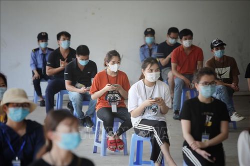 Công nhân ngồi giãn cách chờ tiêm vaccine.